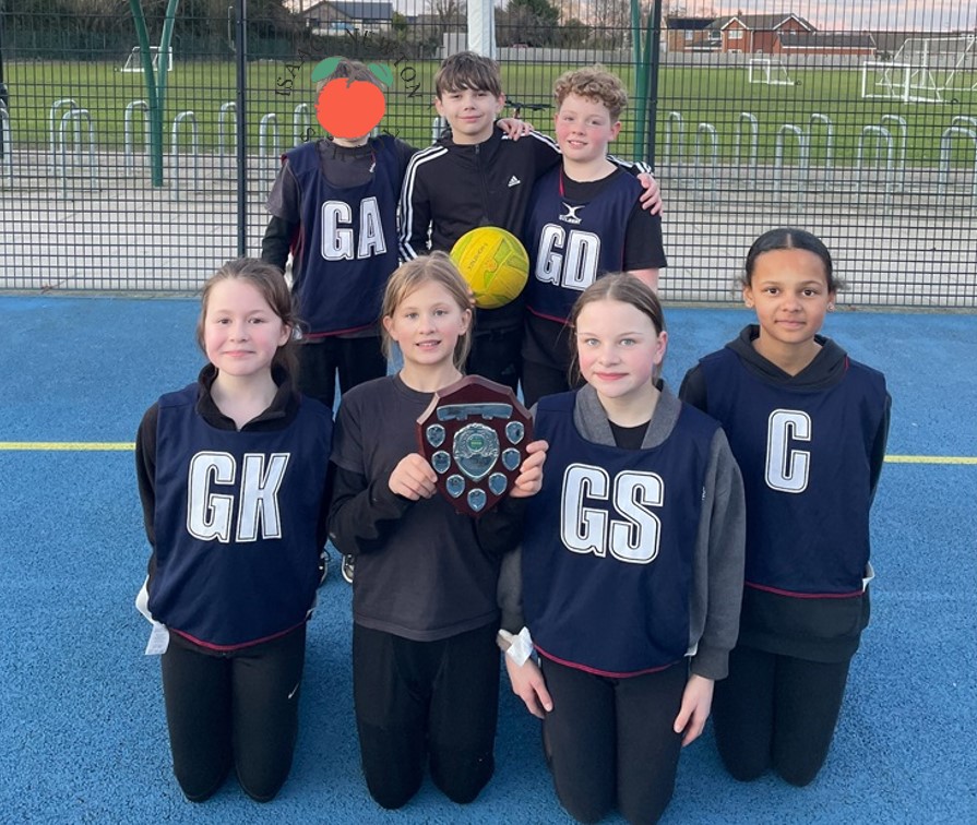 Isaac's Netball Team stand together with their winning trophy