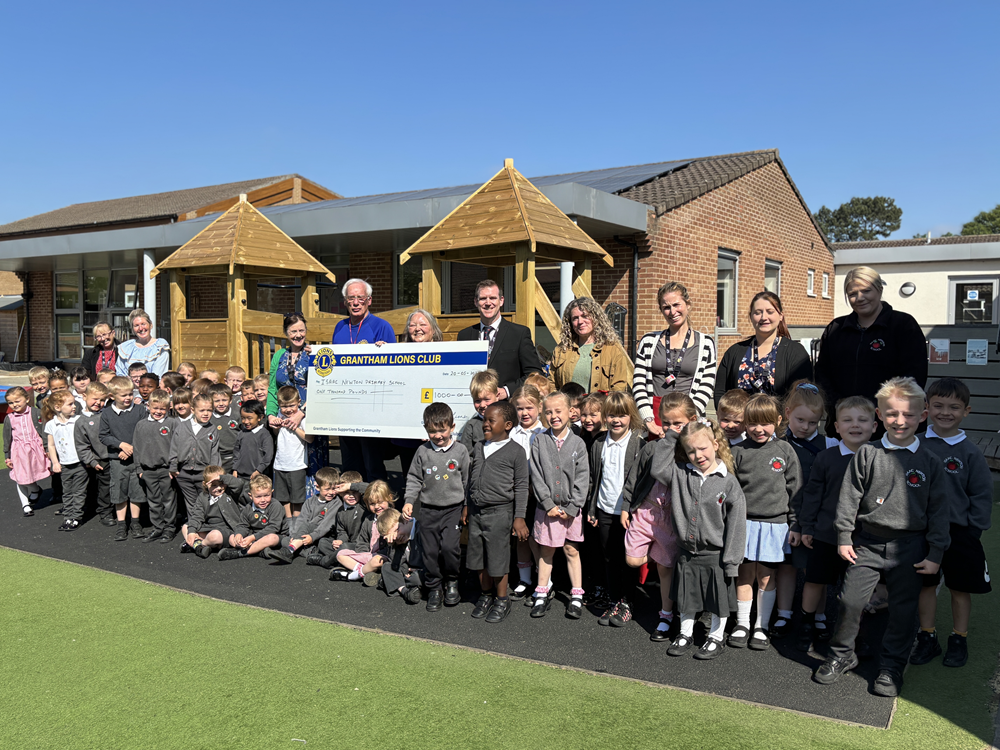 Staff and pupils stand with Lions members and the big cheque