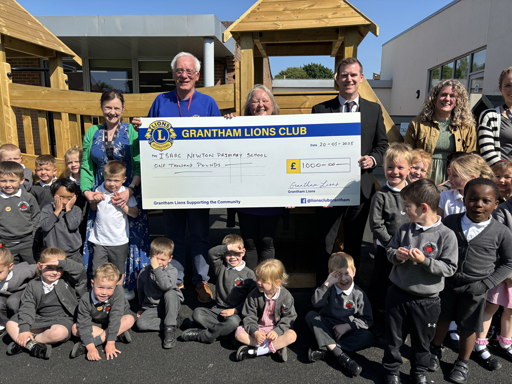 Isaac staff with Lions members, the headteacher and big cheque