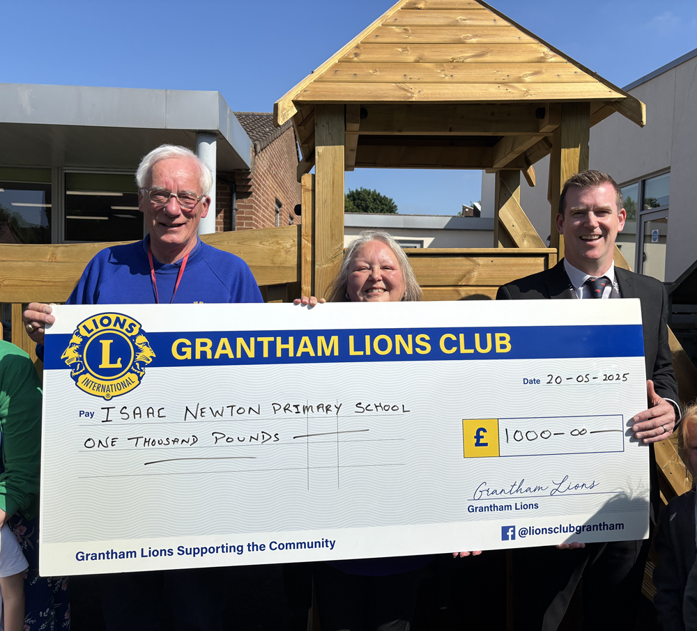 Lions members with the headteacher and big cheque